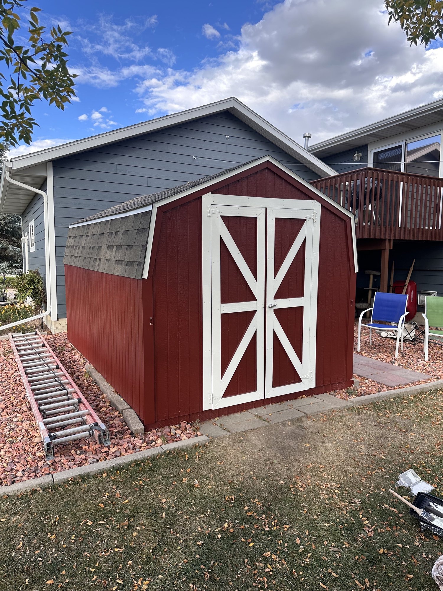 Freshly painted red storage shed with white trim