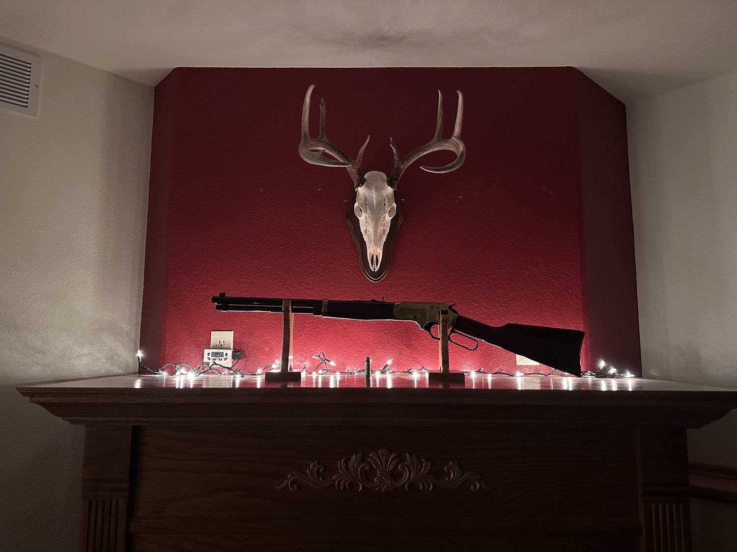 Deep red painted accent wall above a fireplace mantel