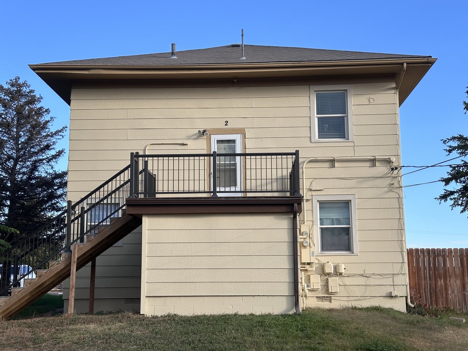 Painted exterior of a two-story building with an outdoor staircase